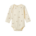 A long-sleeve cream-colored baby bodysuit with a small brown and yellow instrument pattern, displayed flat against a solid white background.