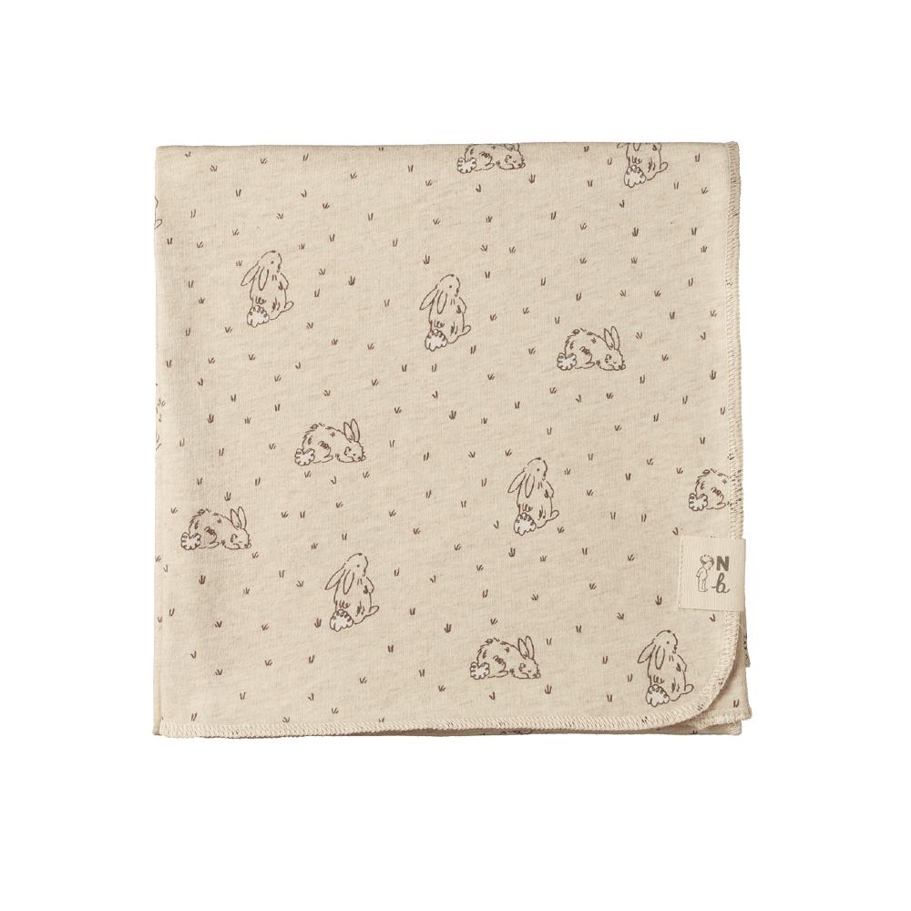 Beige cotton jersey fabric with soft bunny patterns on a white background
