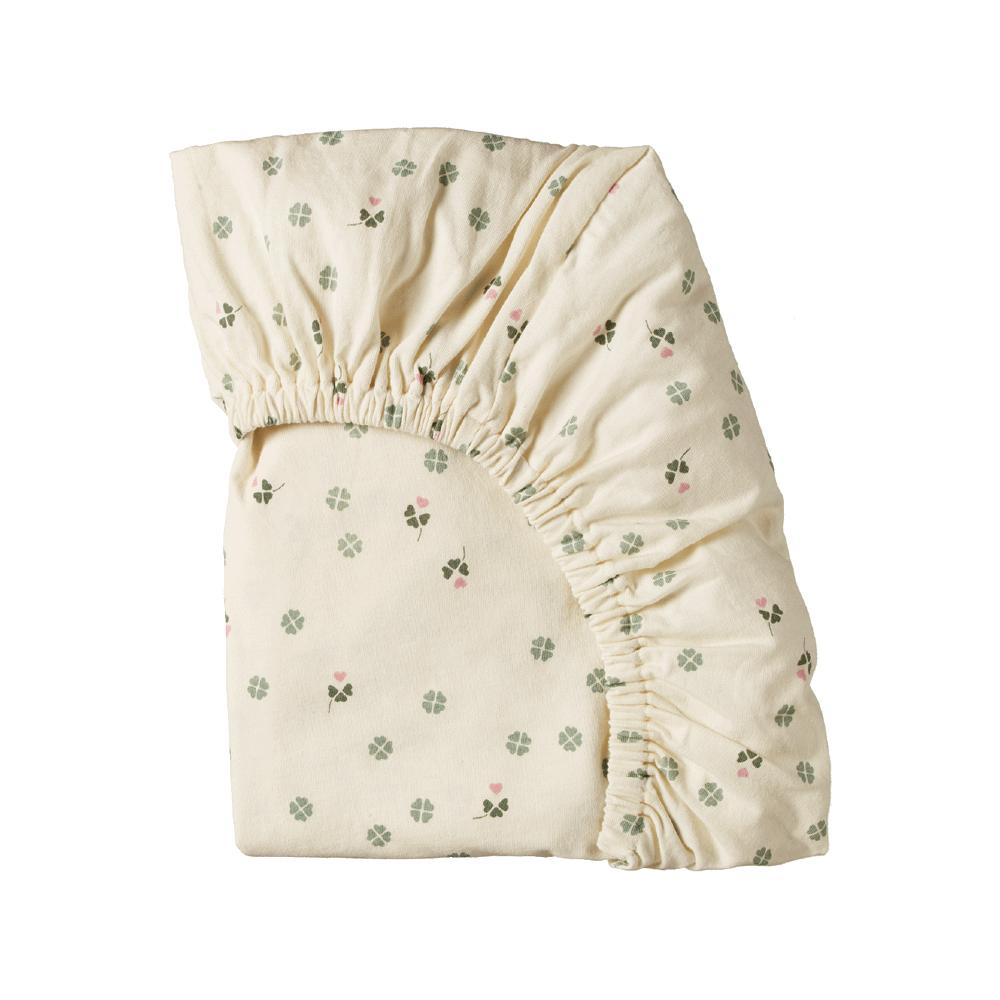 Folded organic cotton jersey fitted sheet fabric with cream and floral pattern on a white background