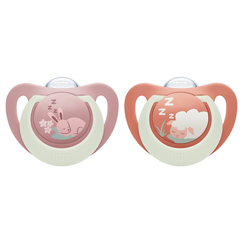 Two NUK baby pacifiers side by side on a white background. The left pacifier has a dusty pink shield and a pale green collar with a pink bunny illustration.