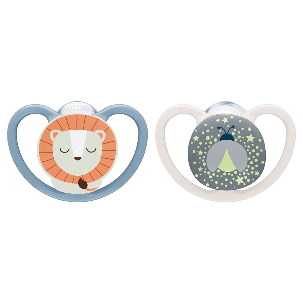 Two baby pacifiers on a plain white background. The left pacifier has a light blue shield with a cartoon lion face in orange, white, and brown.