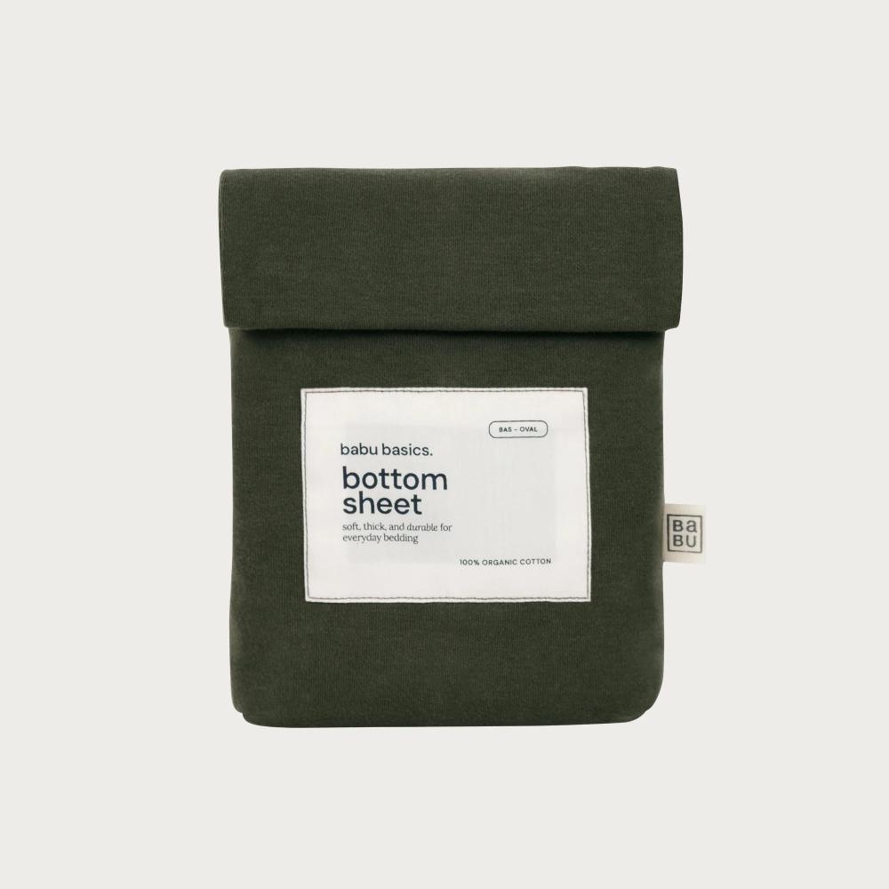 An olive green cotton bottom sheet by babu basics, neatly folded and packaged with a white paper label on a light gray background.