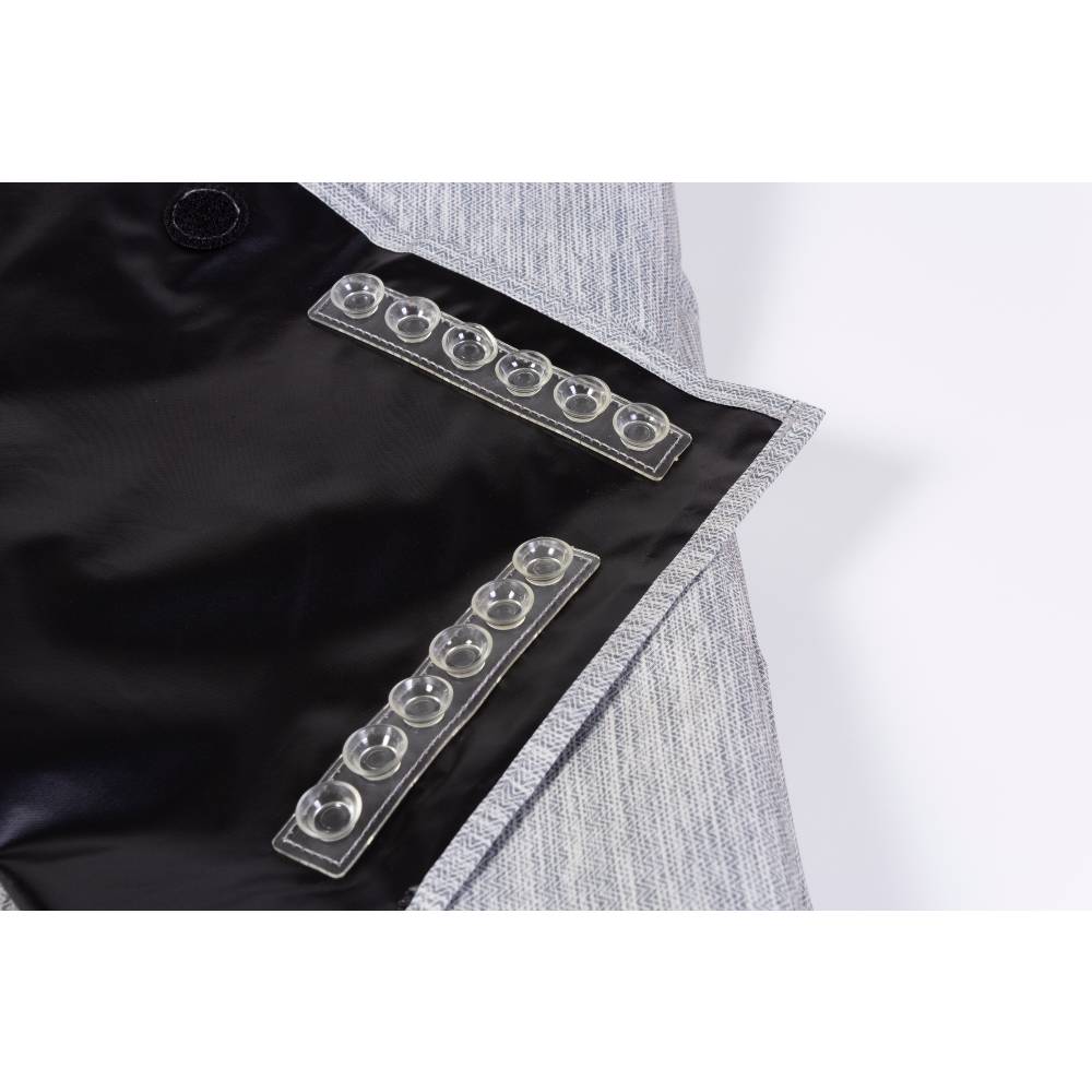 Close-up of a black and gray suckers on blackout blind with metallic buttons on a white background