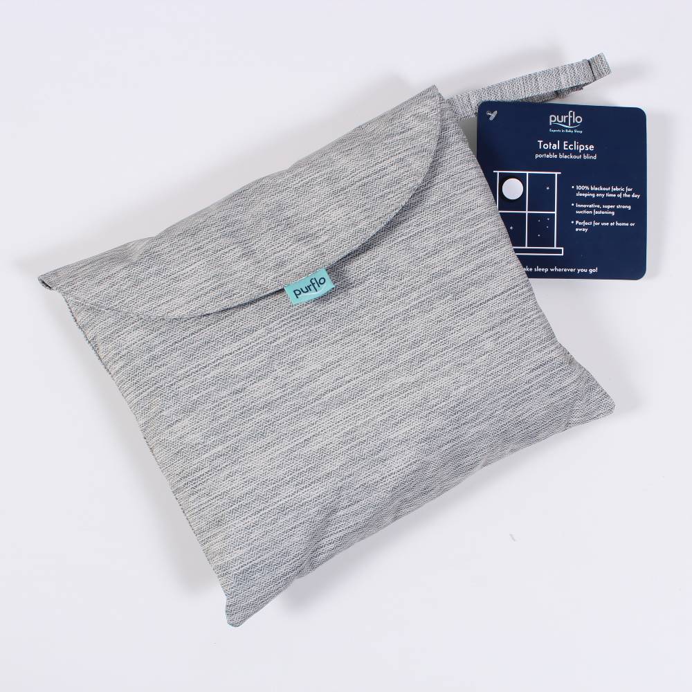 Gray travel blackout blind in travel bag with a blue card on a white background