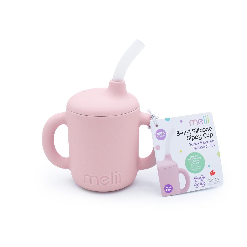 Pink silicone melii 3 in 1 sippy cup with straw and packaging on a white background