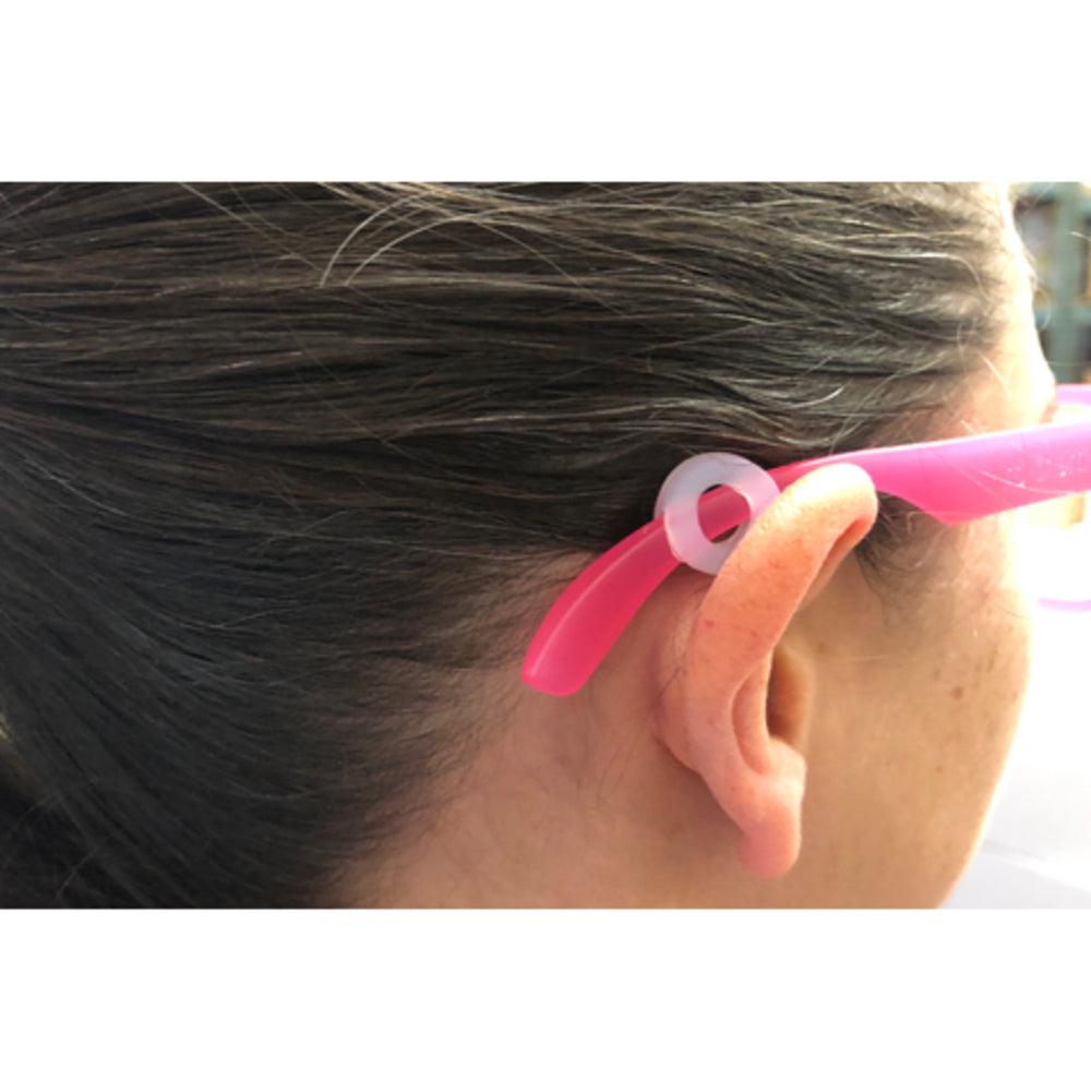 Person wearing pink glasses with slip grip adjuster behind the ear 