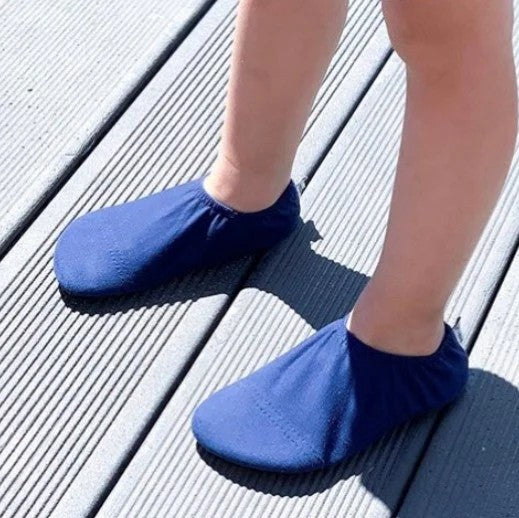 Blue slip-on slipfree shoes worn on a wooden deck