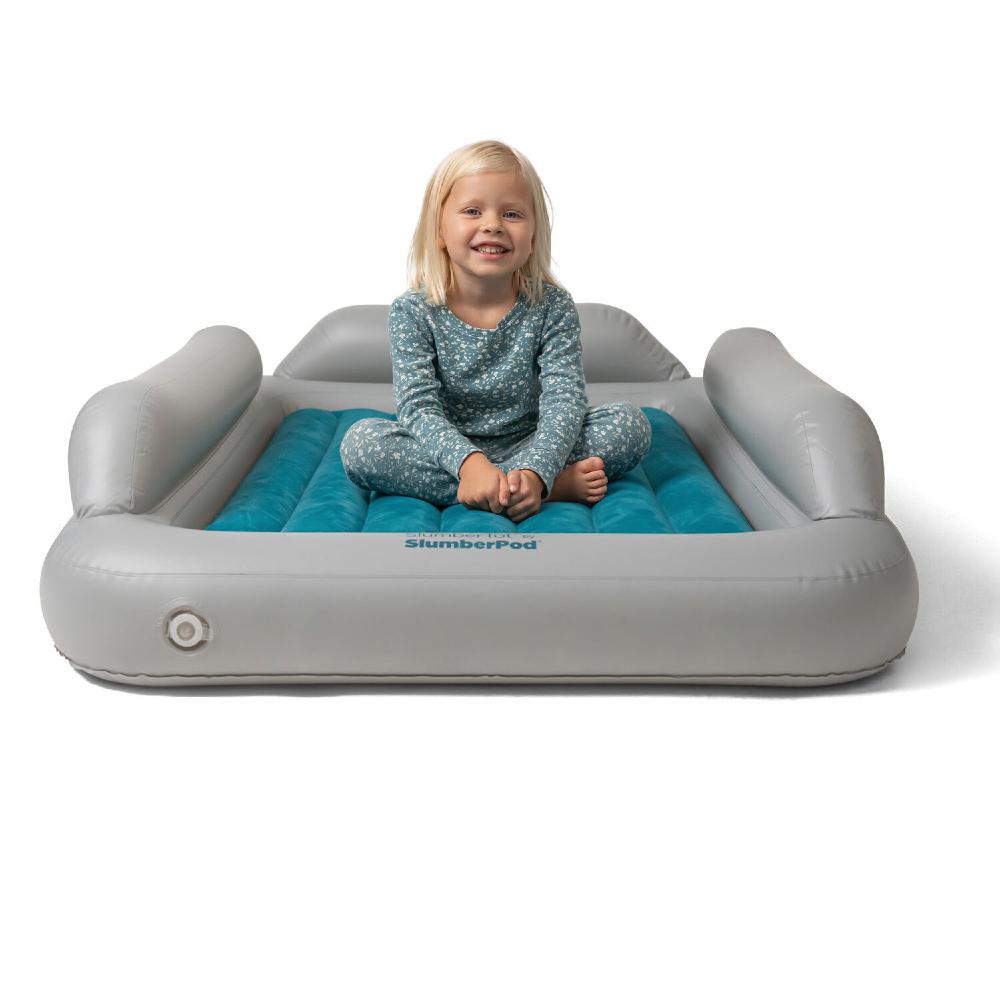 Child sitting on an inflatable SlumberPod with a blue mattress on a white background