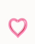 Plastic heart sandwich cutter in pink against a white background