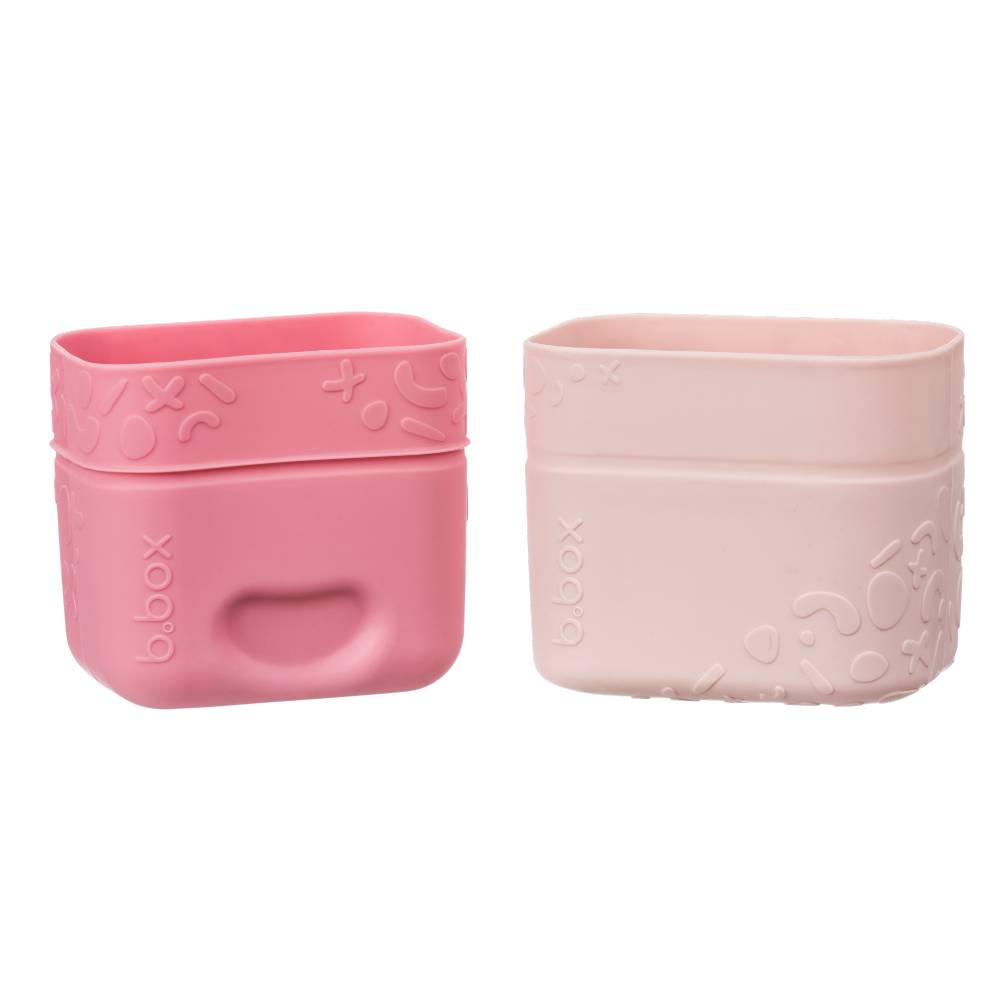 Two pink silicone snack containers with embossed designs on a white background