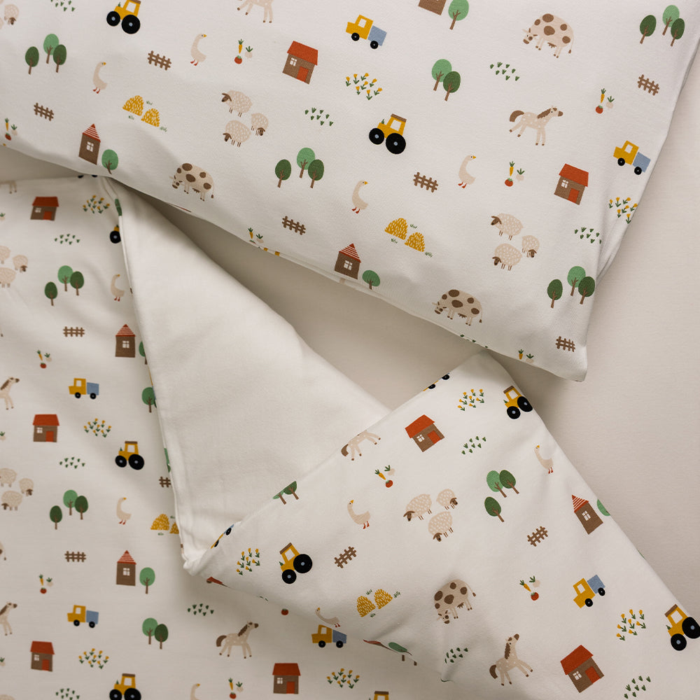 Organic Cotton Cot Duvet Cover - Transport with matching pillowcase on a bed. 