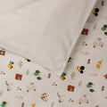 Organic Cotton Cot Duvet Cover - Transport with a white pillowcase on a bed. 