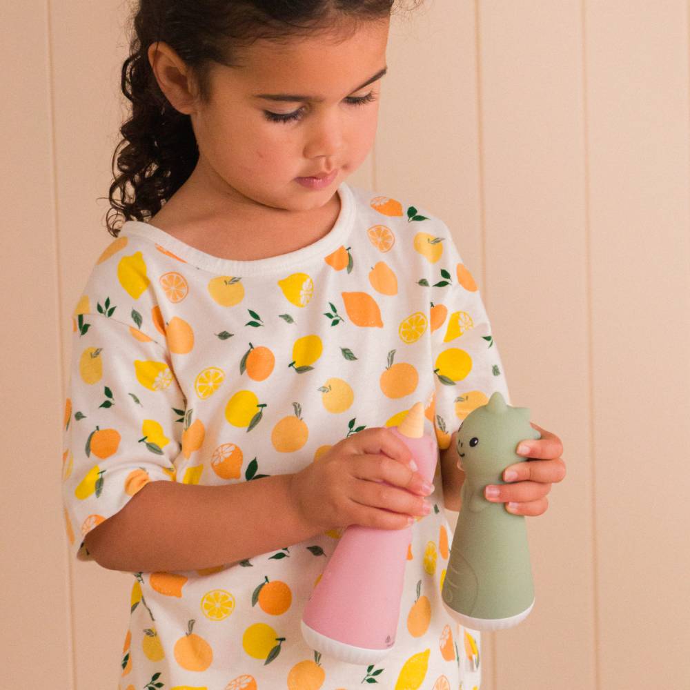 Child holding two small silicone rechargeable night lights against a beige wall