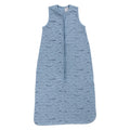A blue sleeveless cotton baby sleep sack with a blue whales shown flat against a white background.