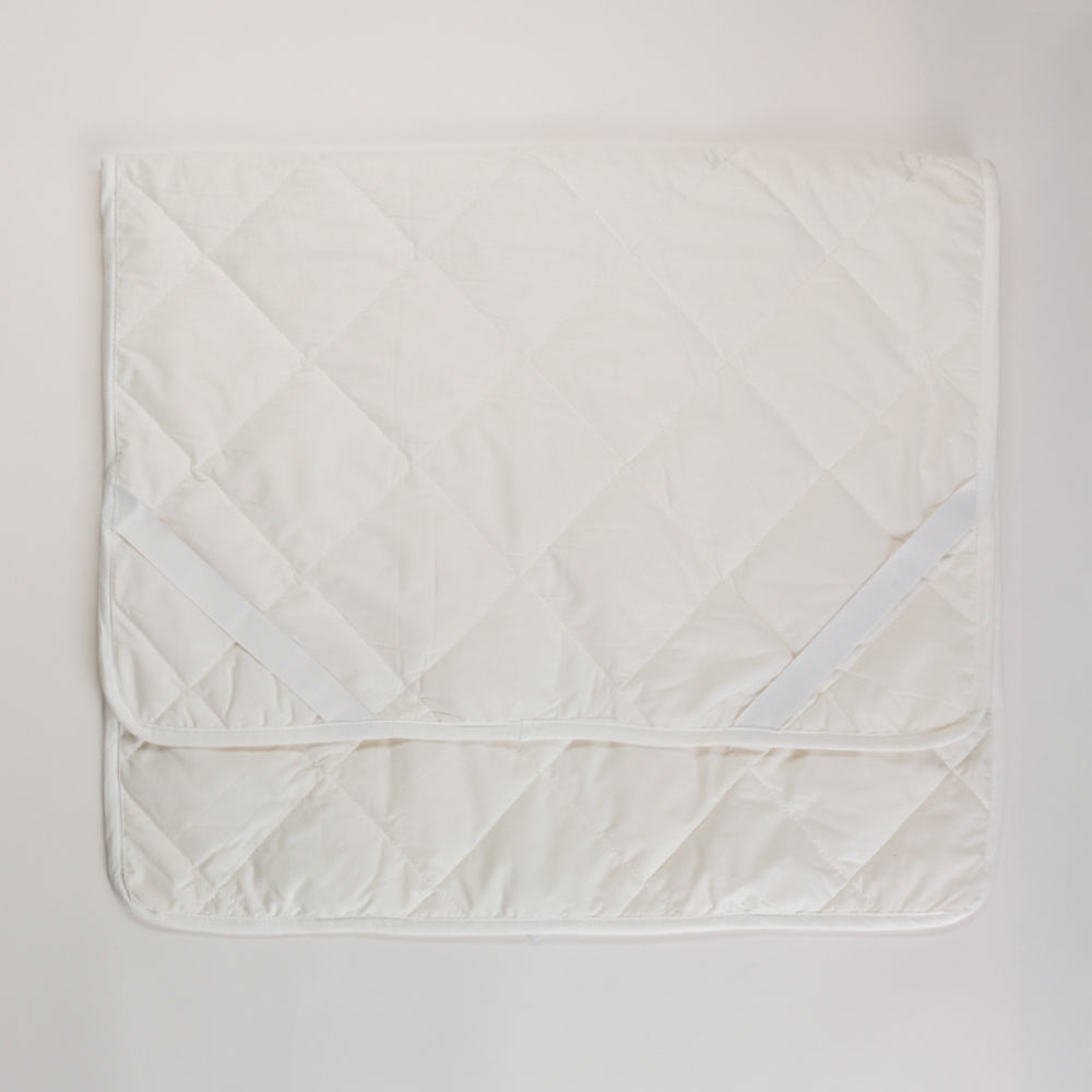 White quilted blanket on a light gray background