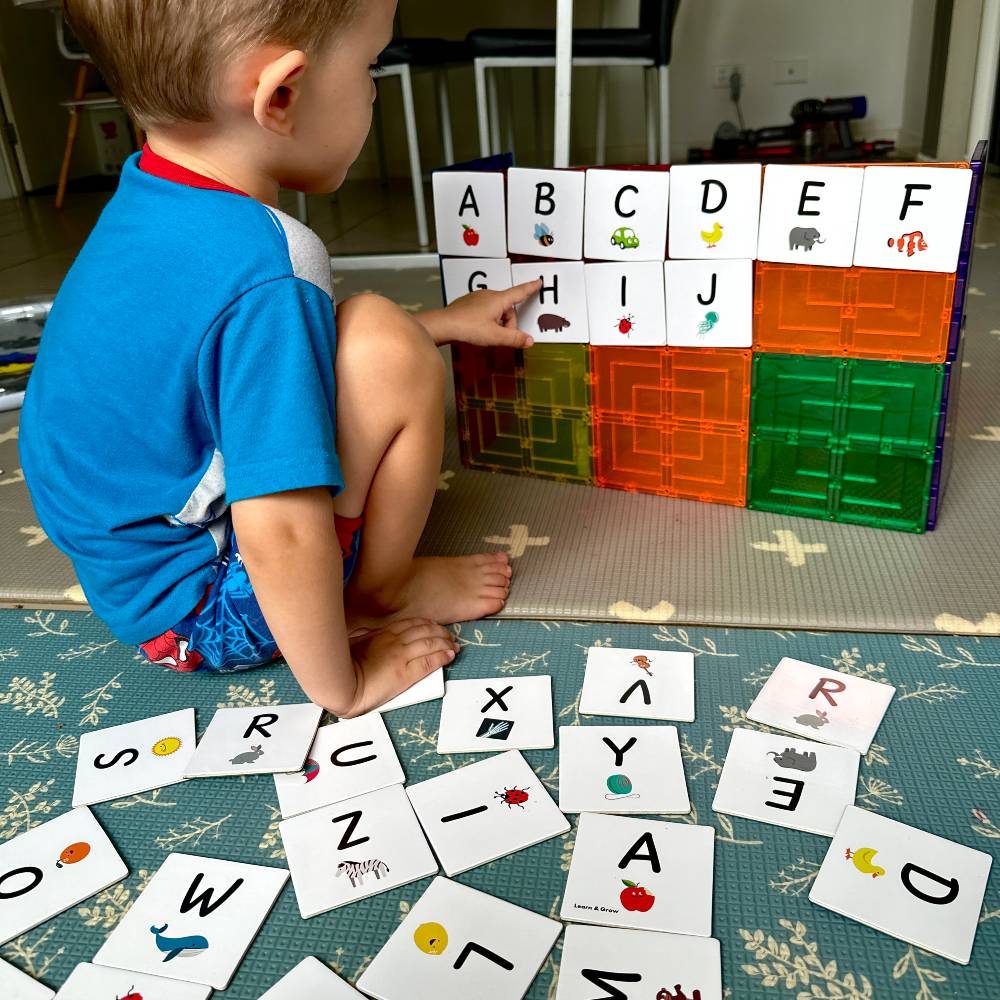 A boy playing with tile tek and tile tek toppers. 