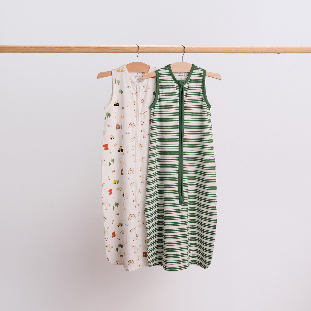 A hanging shot of 2 baby sleeping bags - Farmyard and Pine Stripe. 