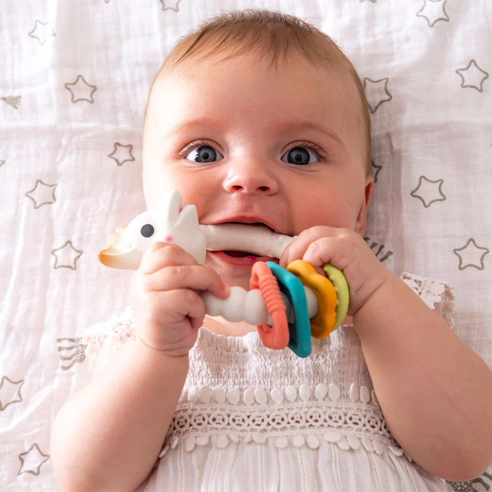 Baby with Sophie La Giraffe - Teething Colo'rings in their mouth for teething. 