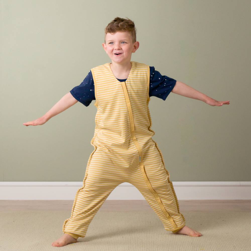 Child wearing a yellow outfit with a patterned shirt against a plain background