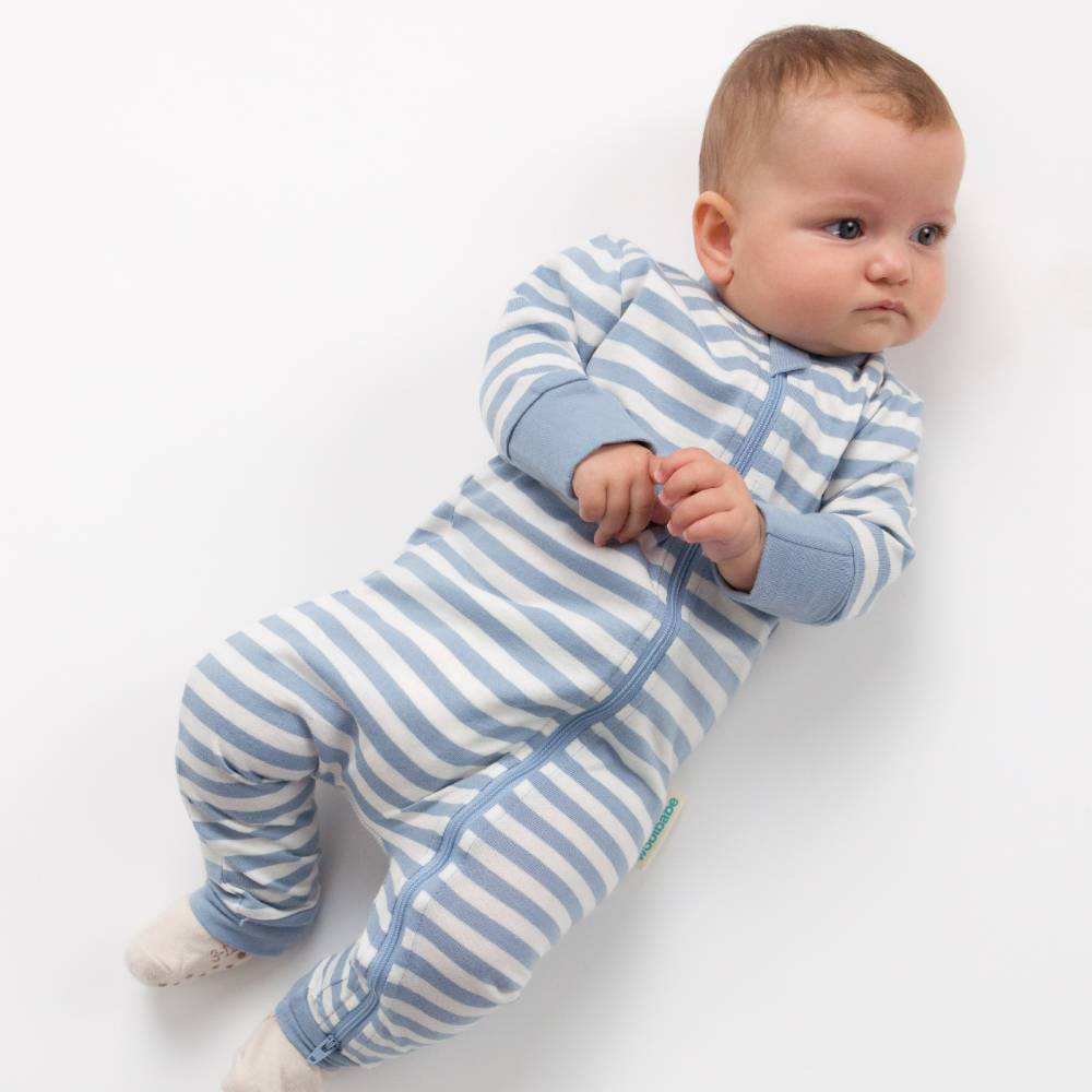 Baby wearing a blue and white striped onesie on a white background