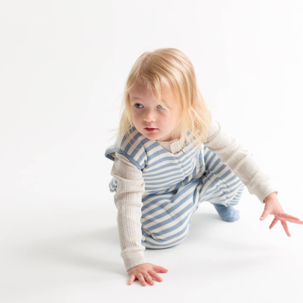 Child wearing a blue and white striped outfit on a white background