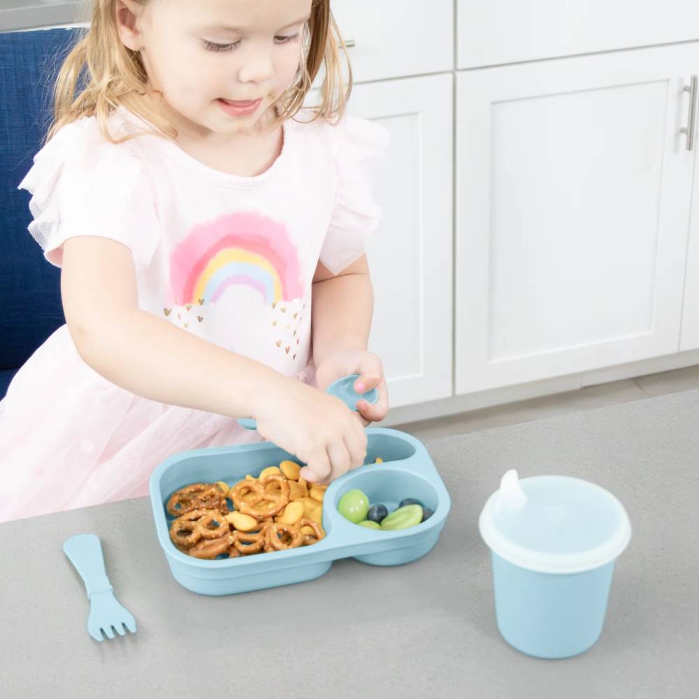 Child eating from a Tiny Tray with a spoon in a kitchen setting