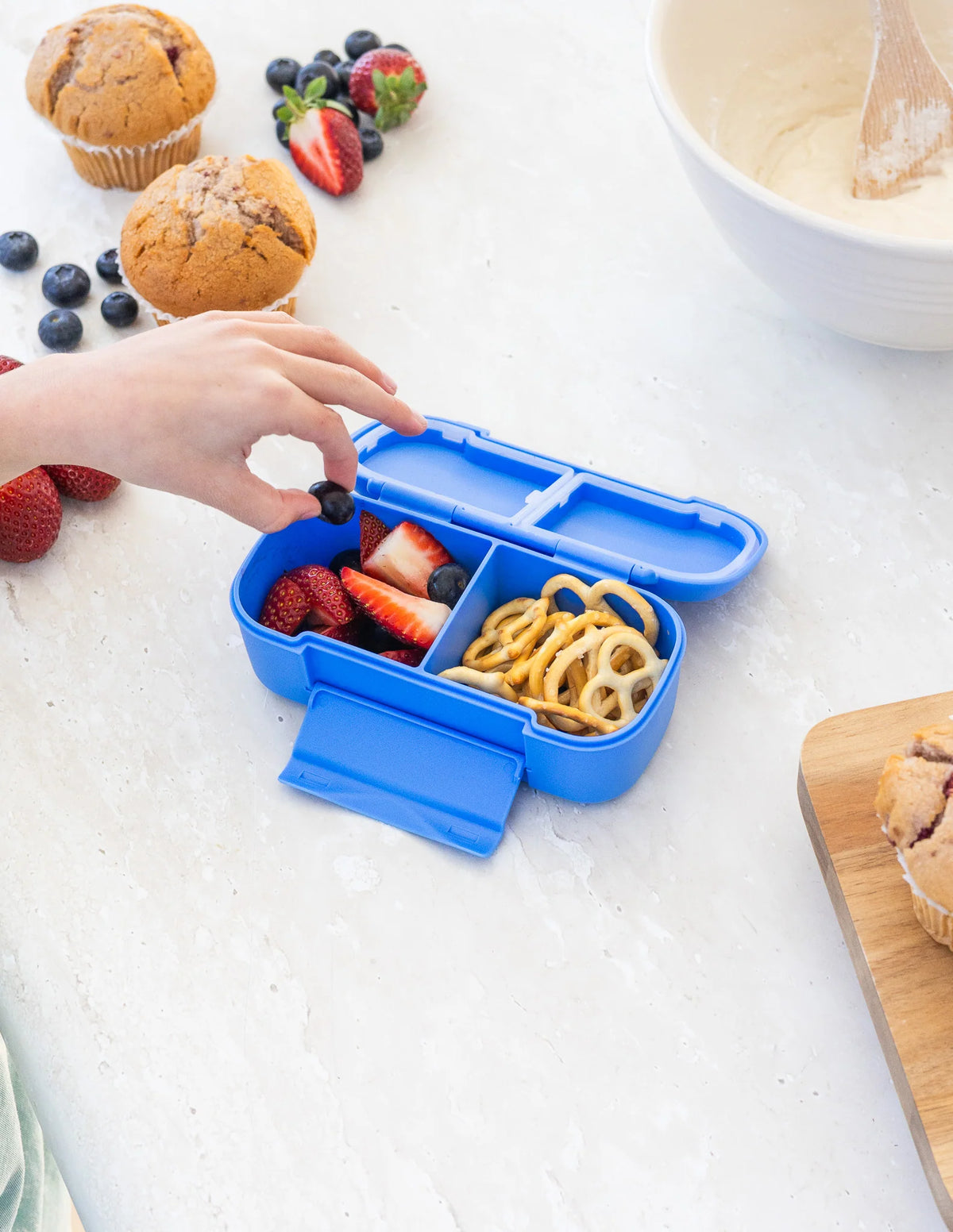 Blue snack box with food inside in a kitchen setting