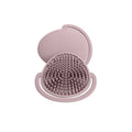A dusty pink silicone scalp massager brush with a matching lid, shown open on a solid white background. The brand name 'shnuggle' is embossed on the lid.
